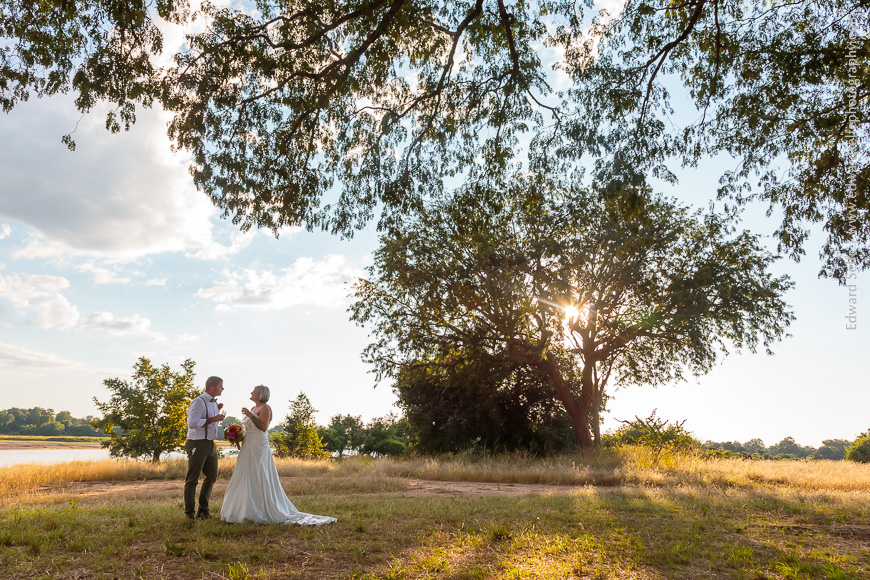 In the shade of a wild mango tree in South Luangwa, a newly married couple take a moment away from the ceremony to celebrate.